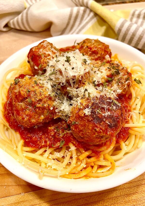 Plate of spaghetti and meatballs with marinara and parmesan cheese