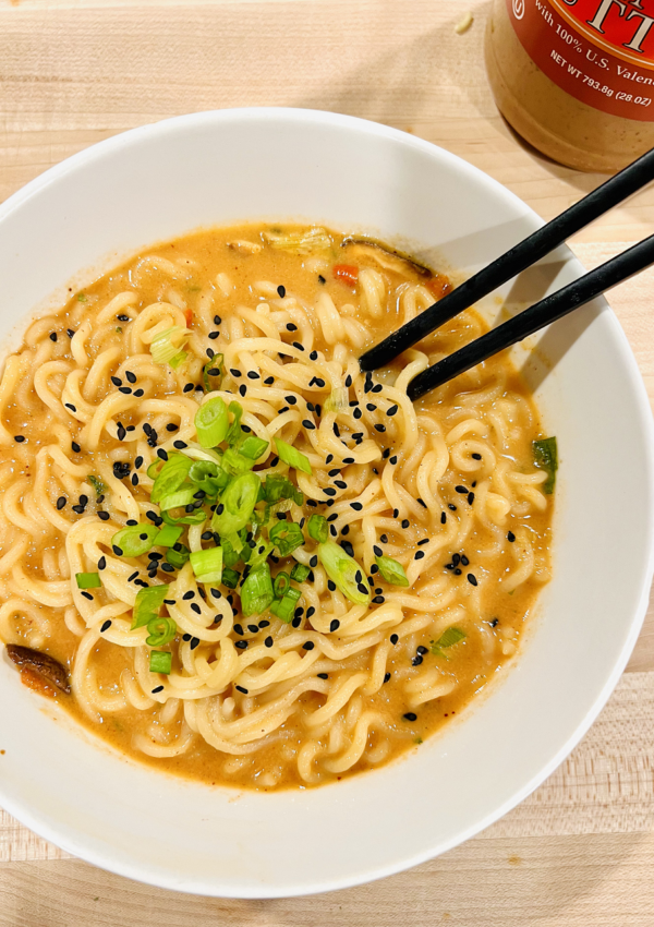 Bowl of Peanut Butter Ramen with green onions and black sesame