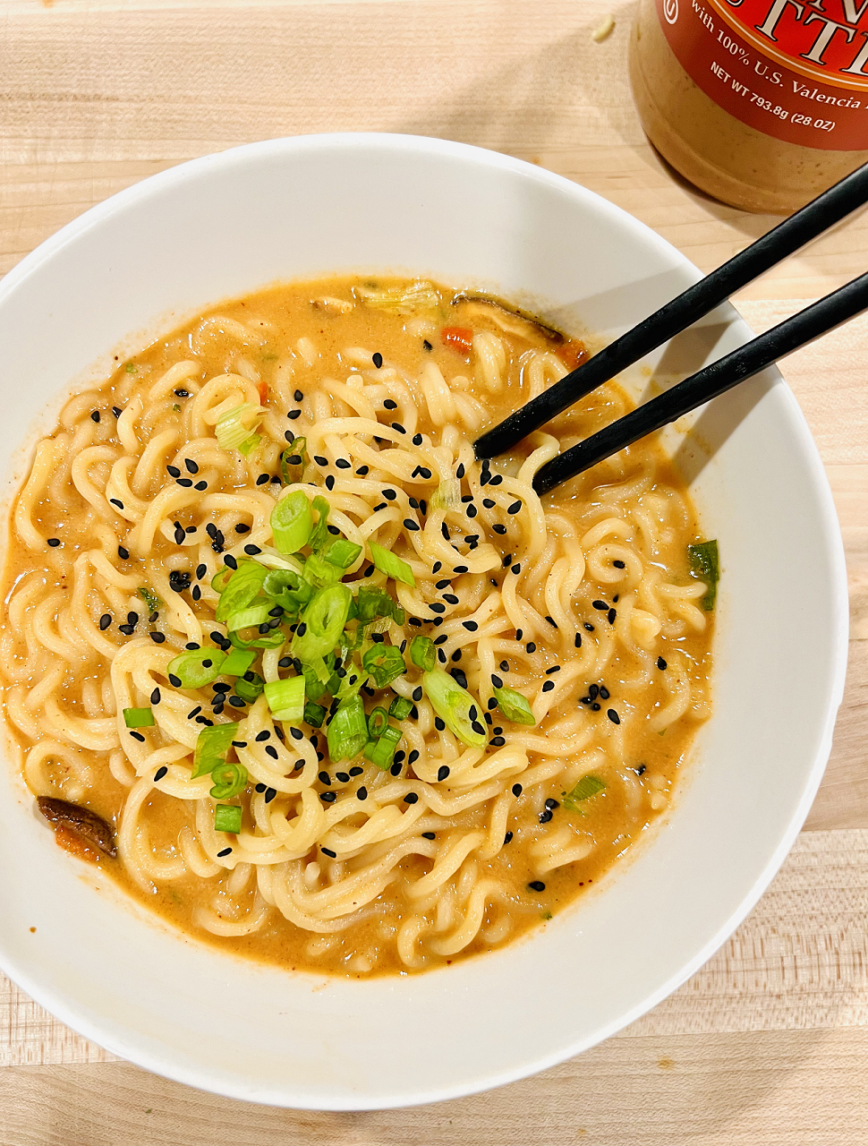 Bowl of Peanut Butter Ramen with green onions and black sesame