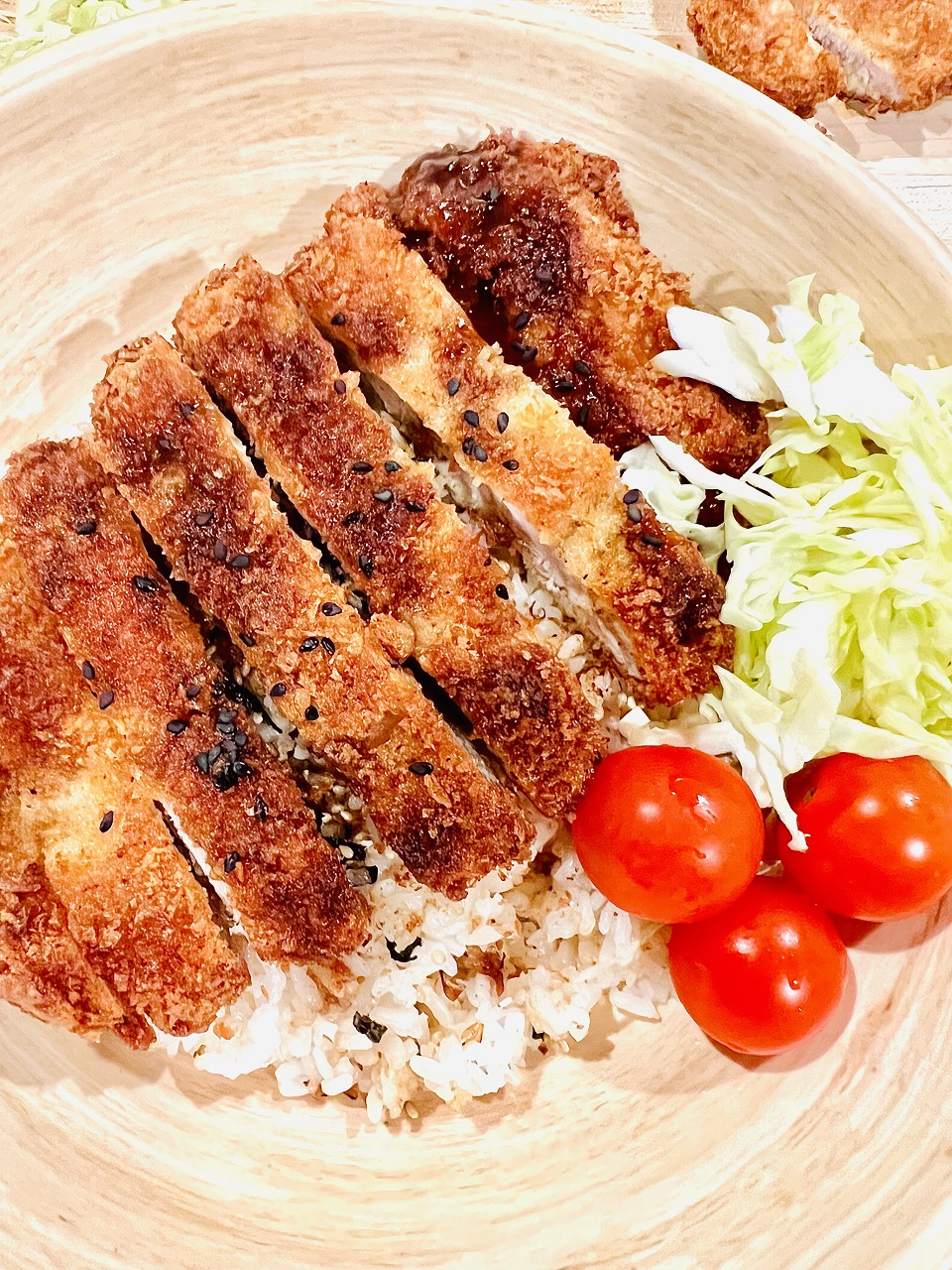 Pork Tonkatsu on white rice with shredded cabbage and cherry tomatoes