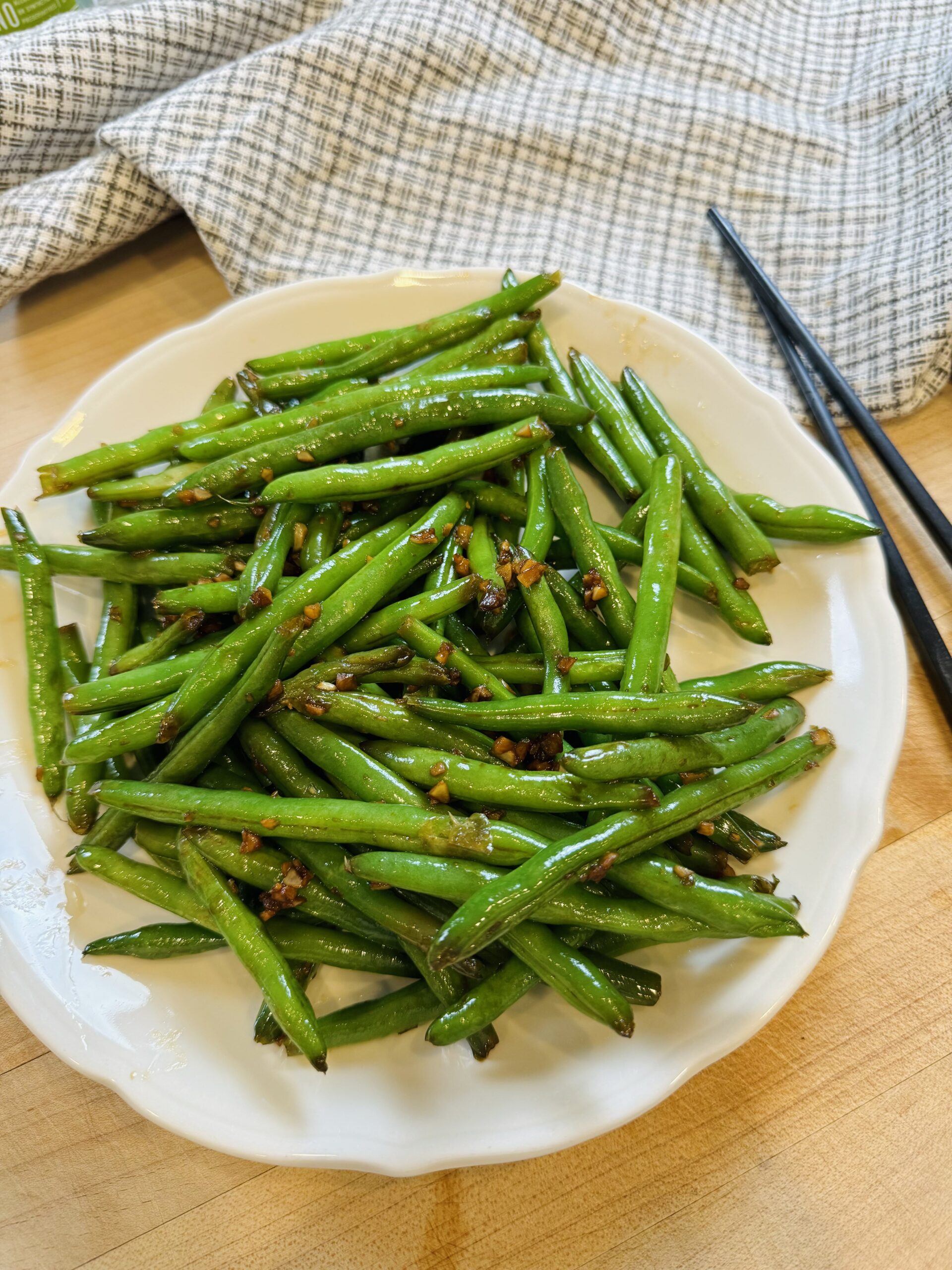 garlic green beans served on a dish with chopsticks on the side