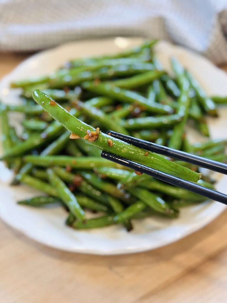 final dish, one of the garlic green beans held up with chopsticks