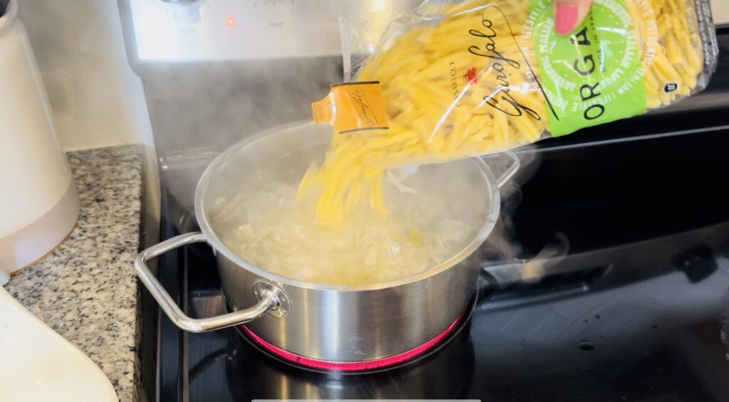 adding the pasta to hot water in the pan