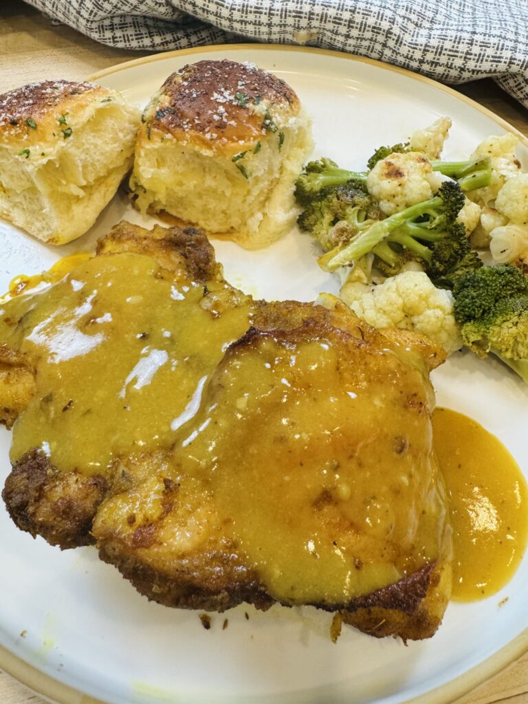 Baked Chicken Thighs with Homemade Gravy, vegetables, and bread rolls