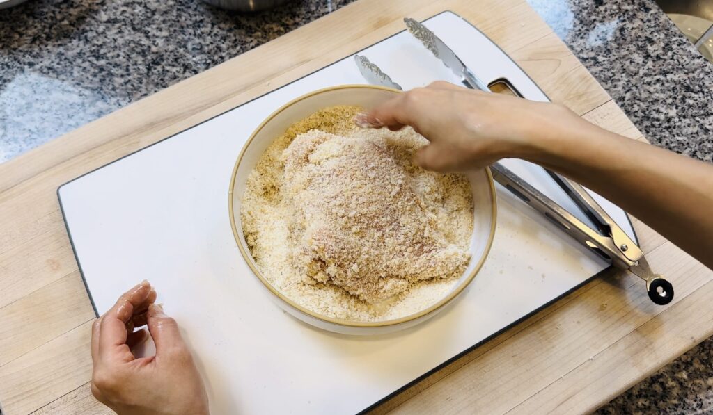 chicken being dipped into breading