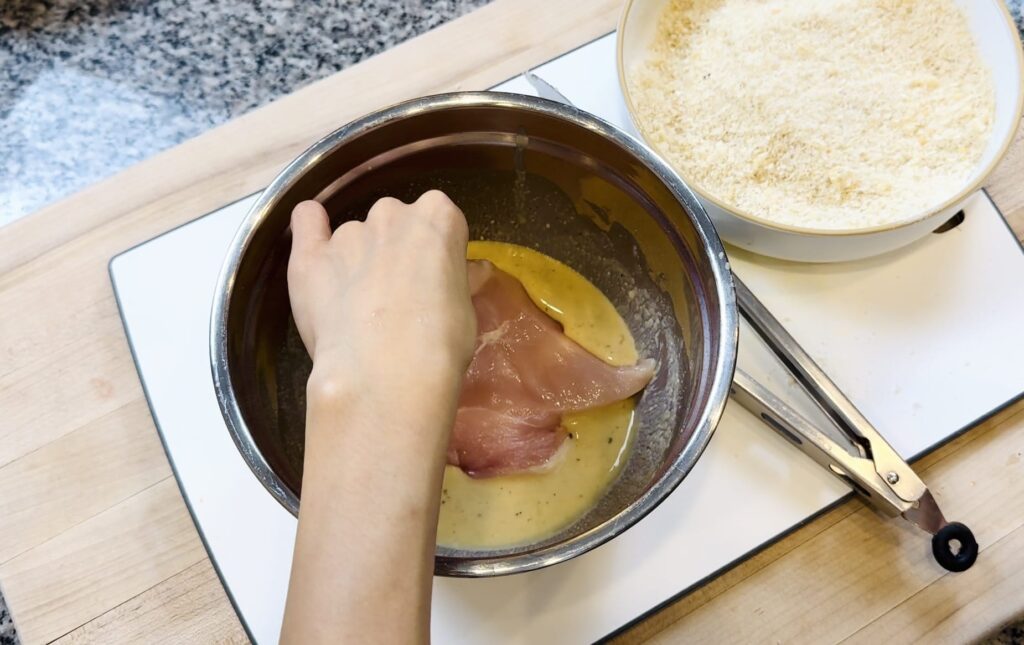 chicken being dipped in batter