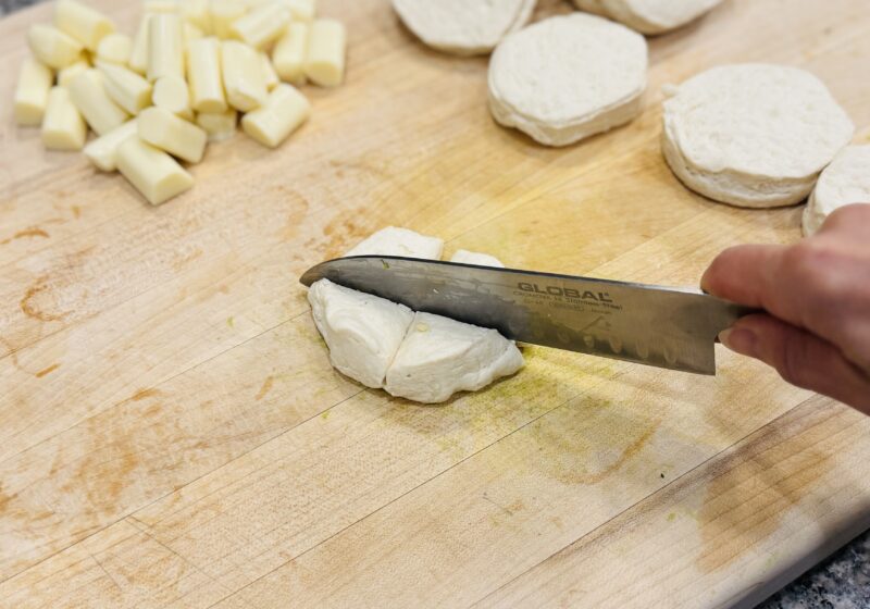 Flatten slice biscuit and a chopped mozzarella cheese on top.