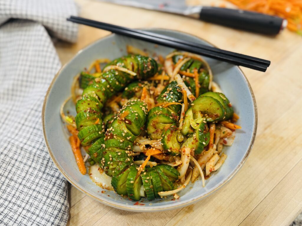Spiral Baby Cucumber Kimchi — ridged baby cucumber pieces tossed in gochugaru, garnished with sesame seeds