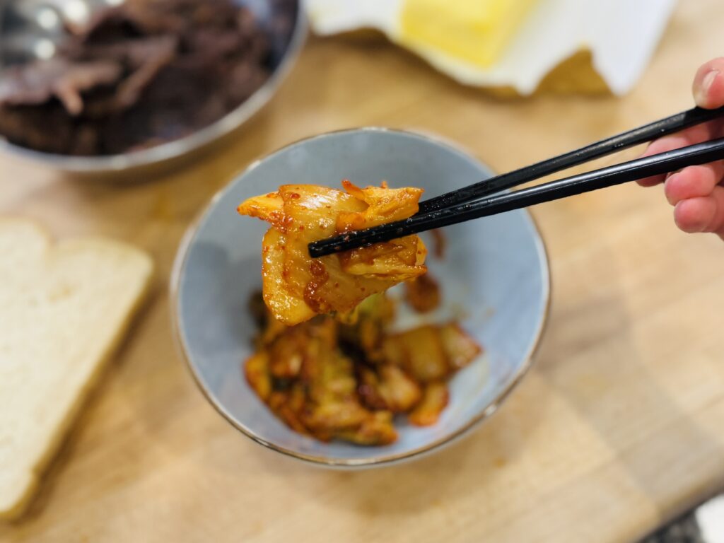 Chopped kimchi caramelized in a skillet over medium heat, turning translucent and golden brown at the edges