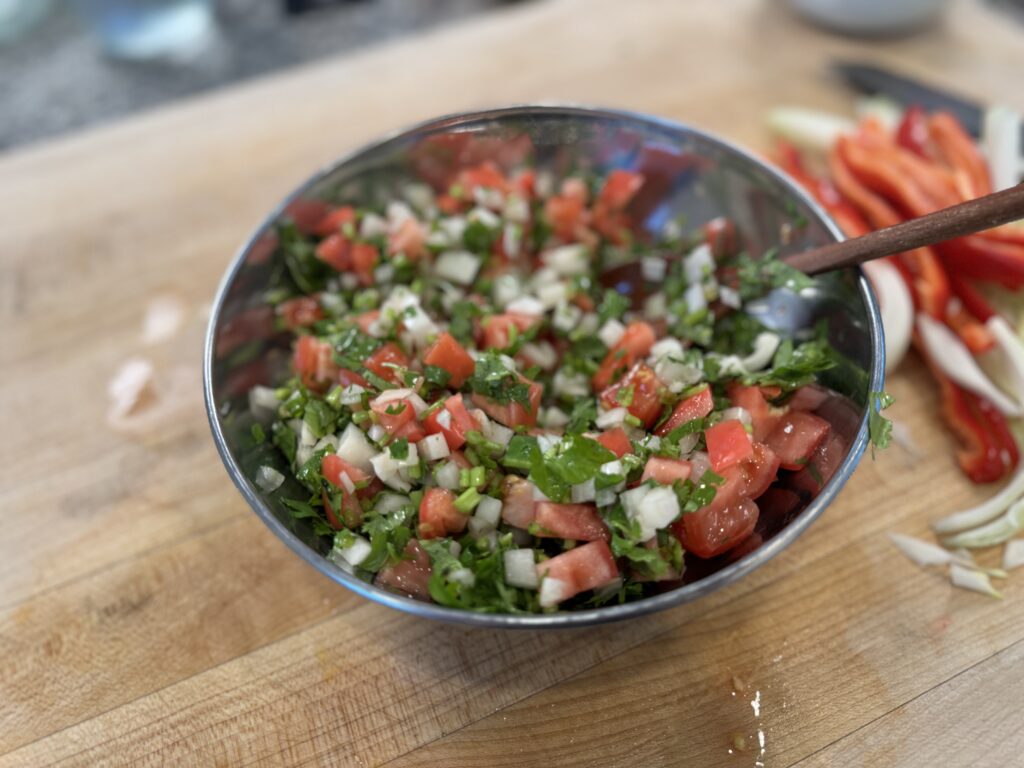 Bowl of freshly made pico de gallo with diced tomato, onion, cilantro, and lime juice — the fresh topping for Mexican hot dogs