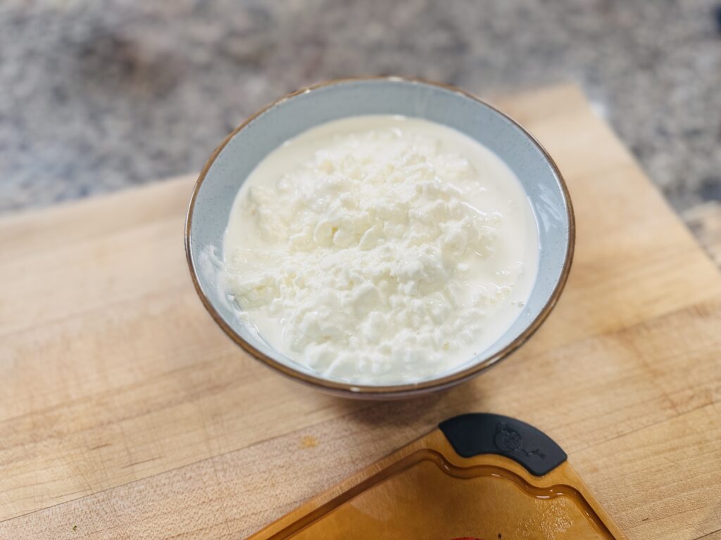 A bowl of plain cottage cheese before blending — the high protein base for the strawberry Biscoff frozen dessert