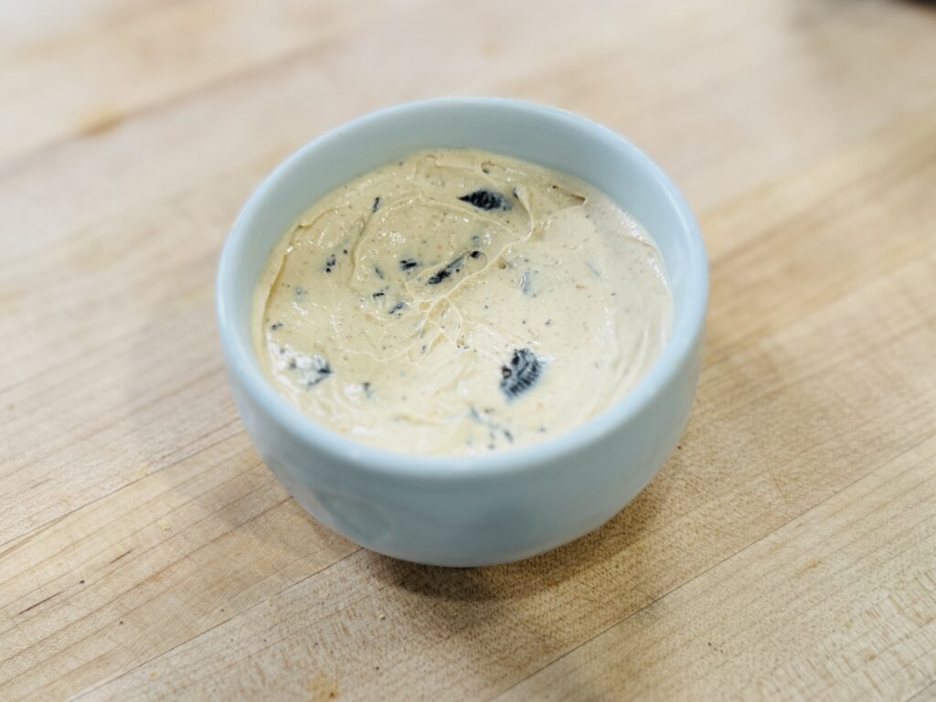 Peanut butter Greek yogurt with crumbled Oreo cookies mixed in, ready for the chocolate shell
