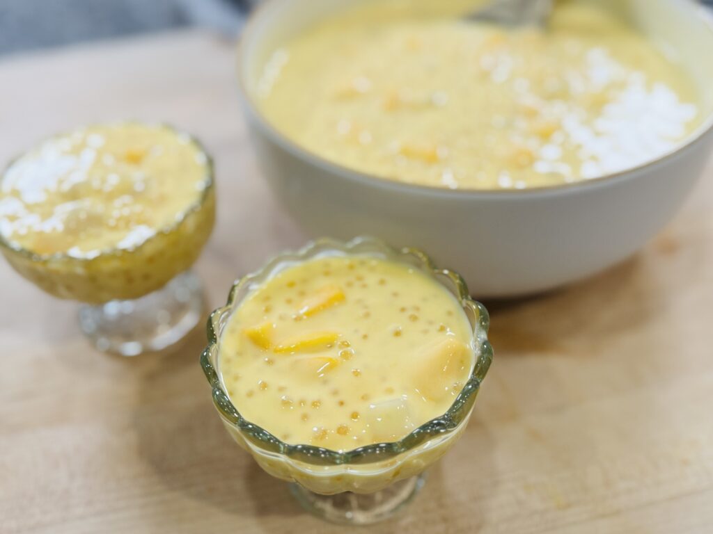 Two cups of mango sago ready to serve with the large bowl in the background