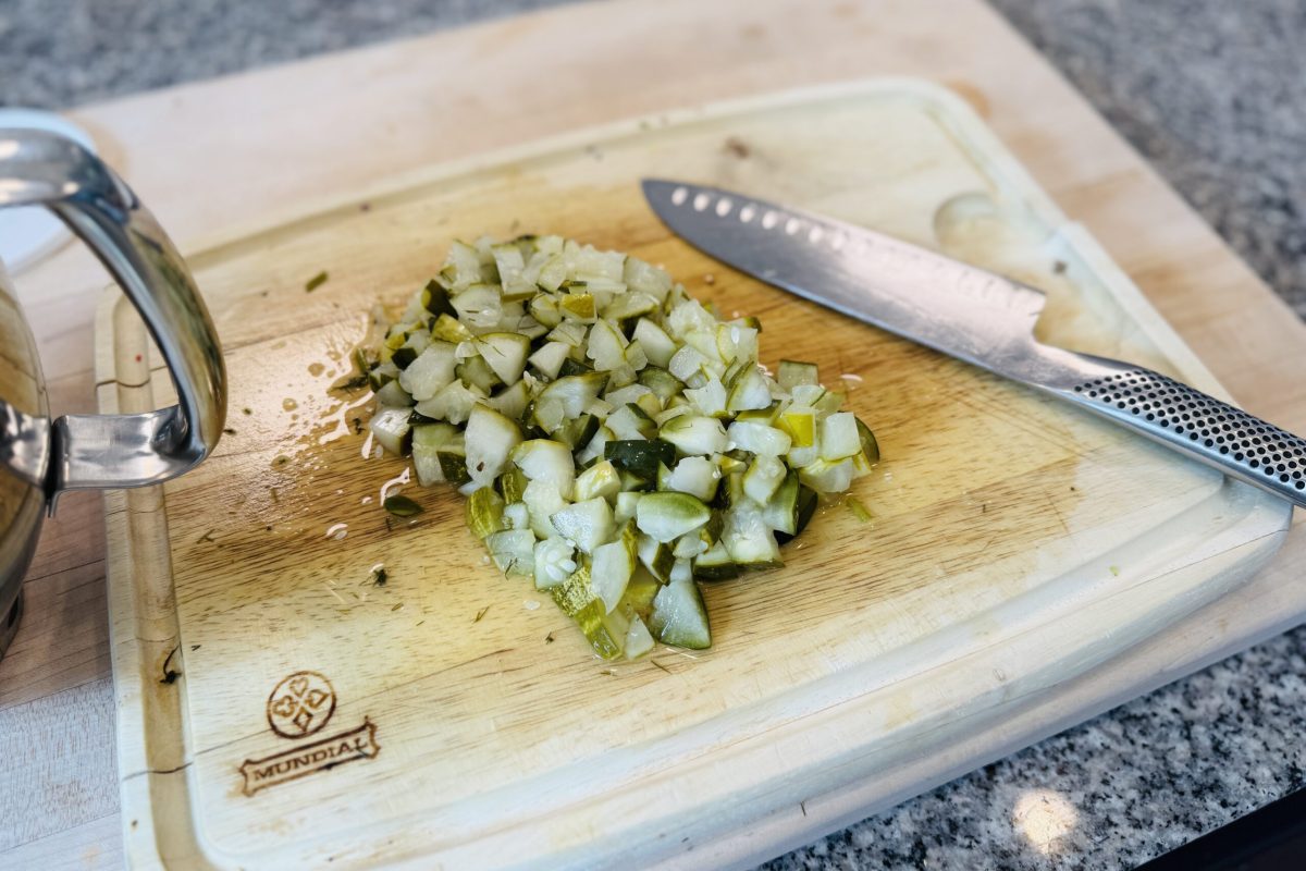 A shot of chopped pickles and knife on the side.